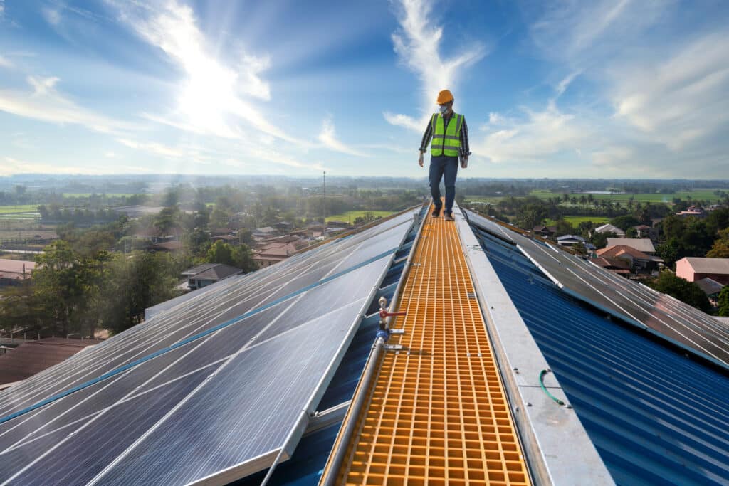Asian technician checks the maintenance of the solar panels, engineering team working on checking and maintenance in solar power plant to innovation of green energy for life on factory roof.