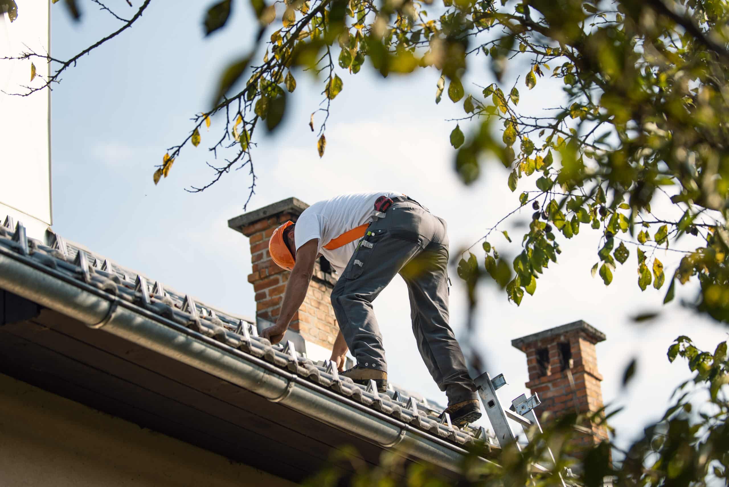 Professional construction worker standing roof top and measuring chimney of new house under construction