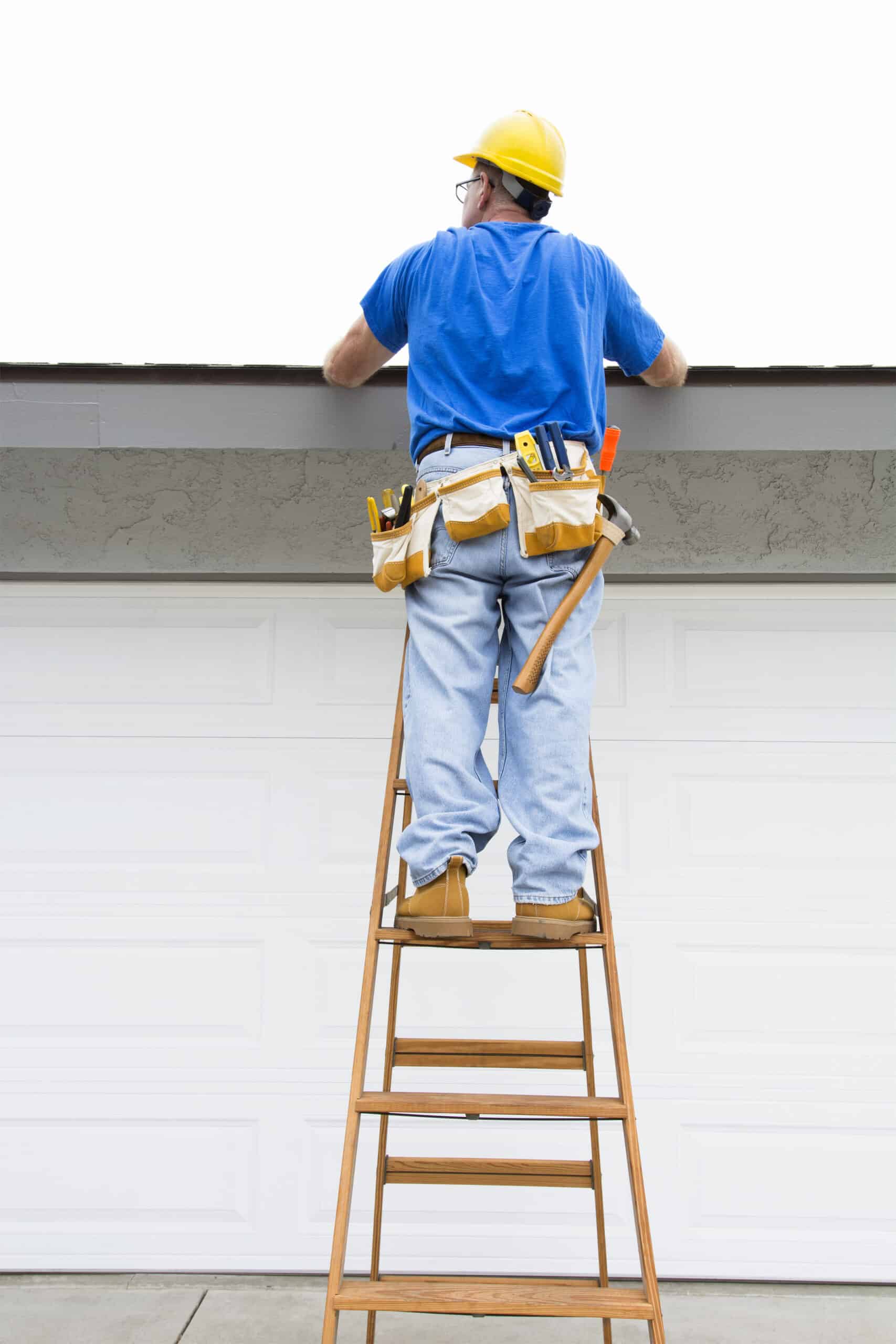 A contractor walks up a ladder to inspect the rook of a residential home during an overcast day